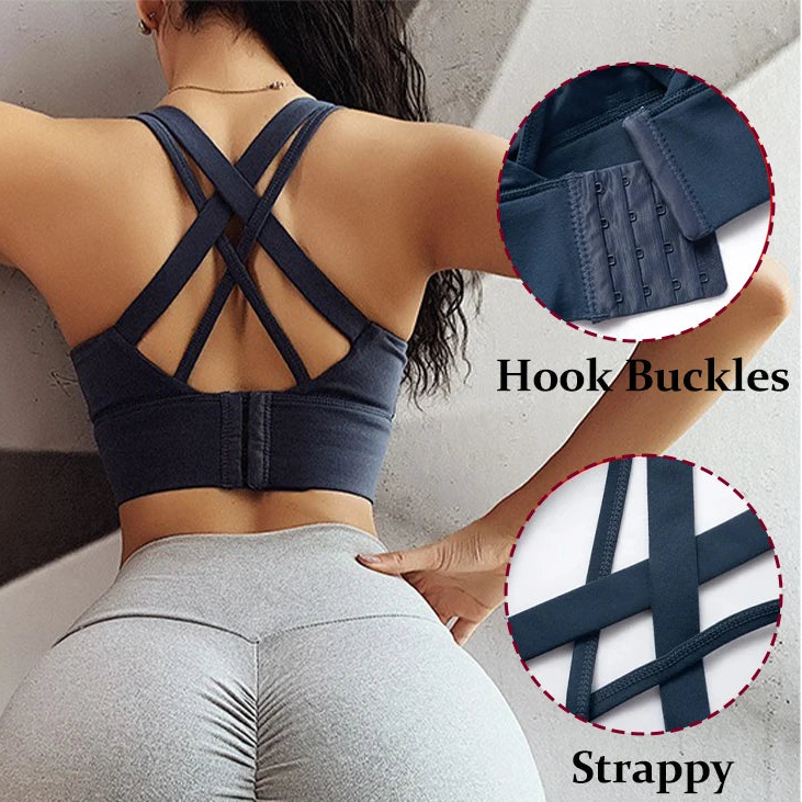 A woman shown from the back wearing a dark navy sports bra with crisscross straps and hook-and-buckle detailing, paired with light gray leggings. Two circular inset callouts highlight the hook buckles and strap design, with text labels 'Hook Buckles' and 'Strappy'.